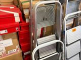 une pile de chaises et une échelle dans un entrepôt