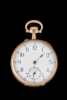 une image représentant une montre de poche en or sur fond noir