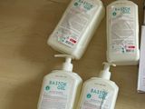 plusieurs flacons de gel hydroalcoolique posés sur une table à côté d'une boîte de savon