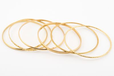 un lot de cinq bracelets en or sur fond blanc
