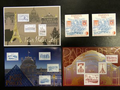 Plusieurs timbres et cartes postales différents sont exposés sur un fond noir