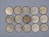 a close up of a bunch of silver coins on a white surface