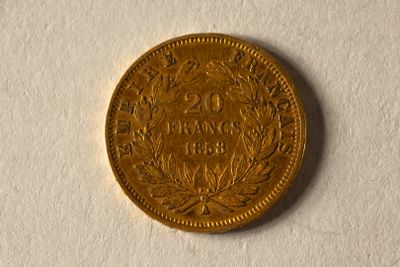 une pièce d'or posée sur une surface blanche