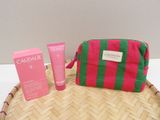 un sac rose et vert posé sur un plateau en osier