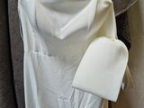 a white dress hanging on a hanger next to a coat