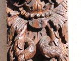 carved wood carving of a woman ' s face on the side of a building