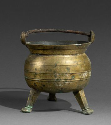 an old brass cauld with a handle on a stand