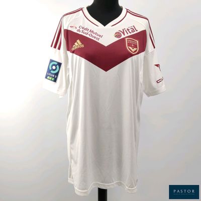 une chemise blanche à rayures rouges et blanches posée sur un présentoir pour mannequin