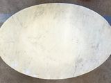 a marble table with a white top on a tile floor