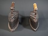 une paire de pinces anciennes en fer et en bois posées sur une surface grise