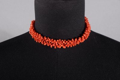 un gros plan d'un mannequin portant un collier rouge sur un mannequin