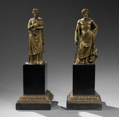 une paire de statues en bronze représentant une femme et un homme, posées sur des socles en marbre