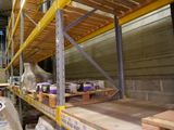 a man standing in a warehouse with a pallet full of boxes