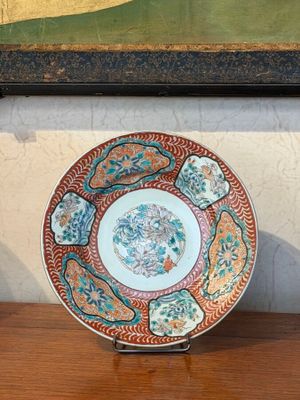 a plate on a table with a painting in the background