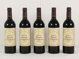 quatre bouteilles de vin rouge sont alignées sur une table