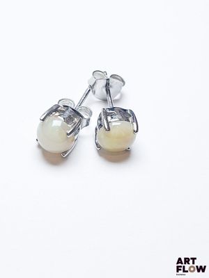 boucles d'oreilles à clous plaquées argent, ornées de perles de verre blanches sur fond blanc