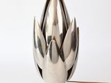un vase en argent posé sur une table blanche