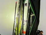 two skis and a snowboard in a bag on the floor