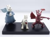 three figurines of animals that are on a black stand