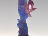 a figurine of a woman holding a bird on a branch
