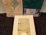 a box of towels and a pair of bathrobes on the floor