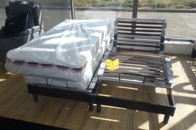 un lit sur lequel est posé un matelas dans une pièce