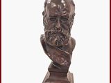 statue représentant le buste d'un homme barbu, posée sur un socle en bois