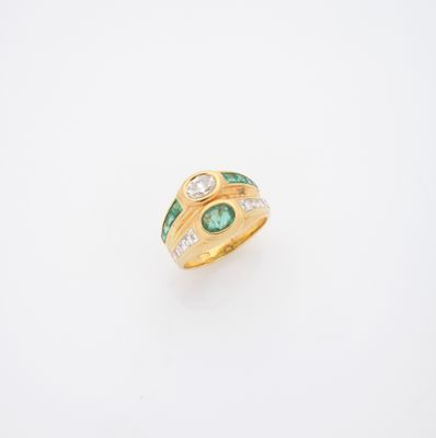 un gros plan sur une bague en or sertie d'une émeraude et de diamants