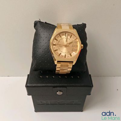 Montre Michael Korsch dorée, présentée dans un coffret noir avec un coussin noir