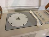 a clock on top of a record player in a room
