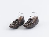 une paire de chaussures marron à lacets posée sur une surface blanche