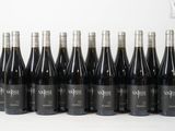 six bouteilles de vin sont alignées sur une surface blanche