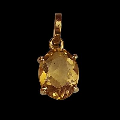 un gros plan d'un pendentif en topaze jaune sur fond noir