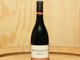 une bouteille de vin posée sur un tonneau