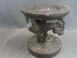a statue of a man holding a bowl on top of a pedestal