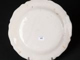 a close up of a white plate on a black surface