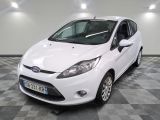 la ford fiesta blanche est garée dans une pièce au sol à carreaux