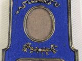 une image représentant une plaque bleue sur laquelle est posé un cadre photo