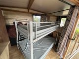 a bunk bed in the corner of a small room