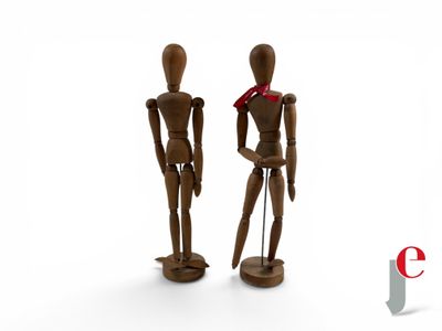two wooden mannequins standing next to each other on a white surface