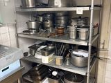 de nombreuses casseroles et poêles sur les étagères de la cuisine