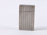 a silver lighter sitting on top of a white surface