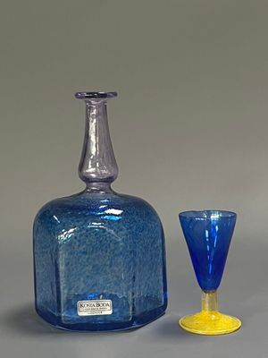 une bouteille en verre bleue et un gobelet en verre jaune