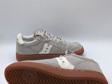 a pair of grey sneakers with brown soles on a white background