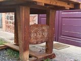 une table en bois sur laquelle est posée une chaise, devant une porte violette
