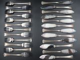 many forks and spoons laid out on a table