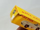 a hand holding a yellow box with a toy car inside of it