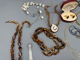 de nombreux bijoux posés sur une table, à côté d'un peigne