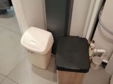 a trash can next to a trash can in a bathroom