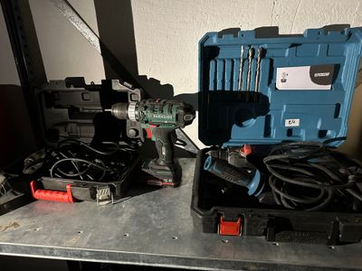 une boîte à outils bleue contenant des outils, posée sur une table en métal